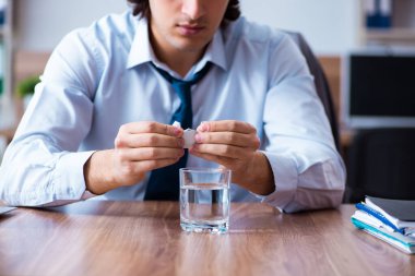 Hasta erkek çalışan ofiste acı çekiyor.