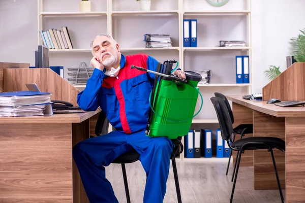 Ancien entrepreneur professionnel faisant de la lutte antiparasitaire au bureau — Photo