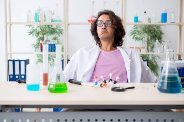 Laboratuvarda çalışan komik erkek kimyager.