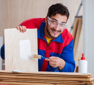 Yooung marangoz boyayla uğraşıyor.