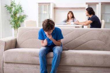 Genç bir çocuk ve ailesiyle sigara içme kavramı