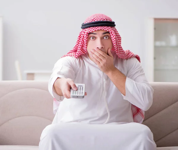 Junger arabischer Mann vor dem Fernseher sitzt auf dem Sofa — Stockfoto