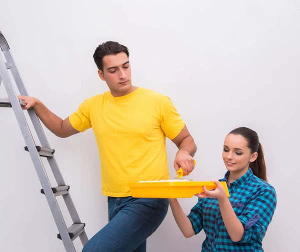 Jovem casal parede de pintura em casa — Fotografia de Stock