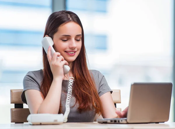 Young woman talking on phone in office — Stock Photo, Image