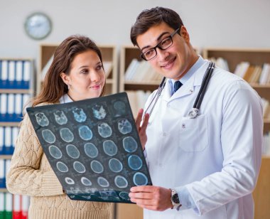 Genç doktor bilgisayardaki röntgen görüntülerine bakıyor.