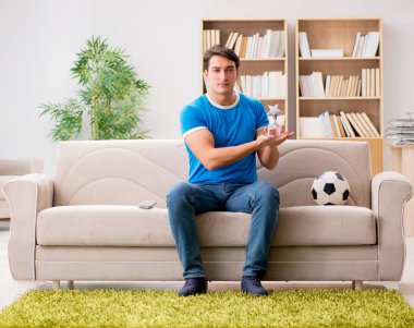 Adam evde futbol izlerken