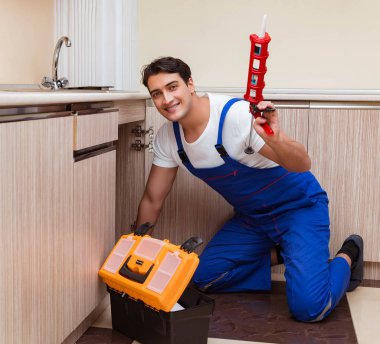 Mutfakta çalışan genç tamirci.