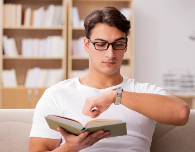 Kanepede kitap okuyan bir adam.