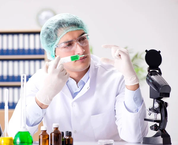 Médico joven trabajando en el laboratorio con microscopio —  Fotos de Stock