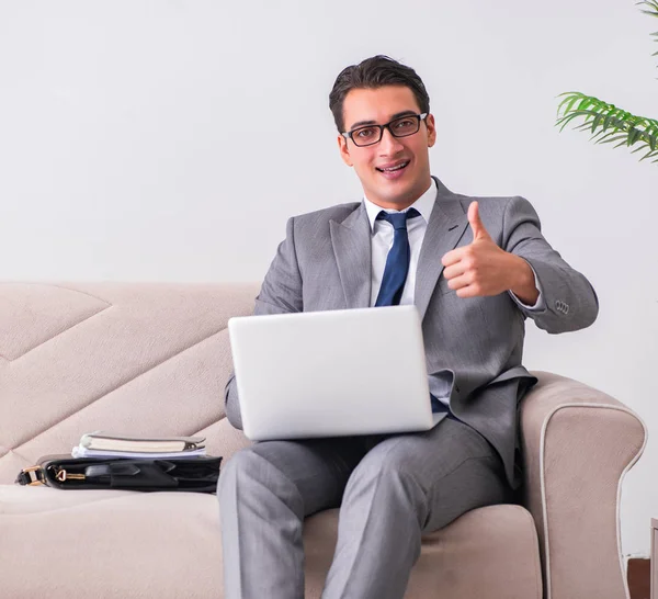 Бизнесмен с ноутбуком сидит на диване — стоковое фото