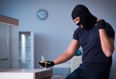 Soyguncu kar maskesi takıp değerli şeyler çalıyor.