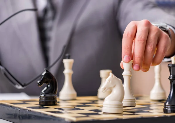 Young businessman playing chess in the office