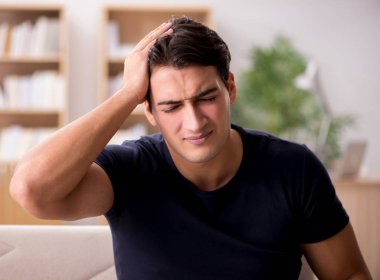 Acı çeken genç yakışıklı adam.