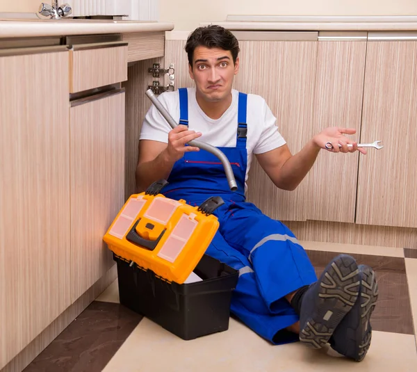 Joven reparador trabajando en la cocina — Foto de Stock