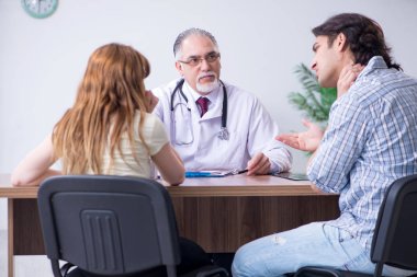 Genç çift yaşlı erkek doktoru ziyaret ediyor.