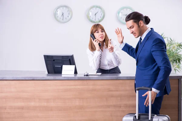 Joven hombre de negocios en recepción del hotel — Foto de Stock