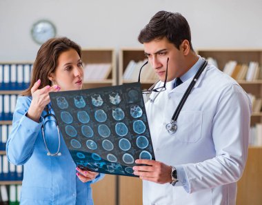 Genç doktor bilgisayardaki röntgen görüntülerine bakıyor.