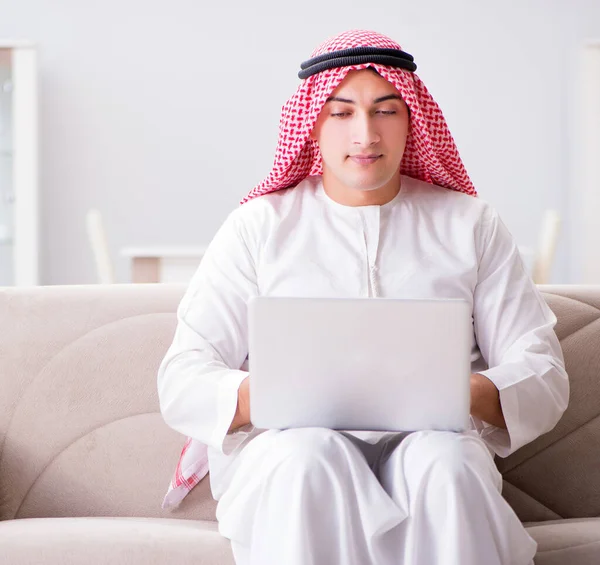 Genç Arap işadamı kanepede dizüstü bilgisayarla çalışıyor. — Stok fotoğraf
