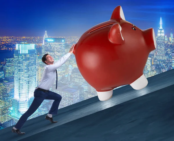 Man pushing piggybank uphill in business concept — Stock Photo, Image