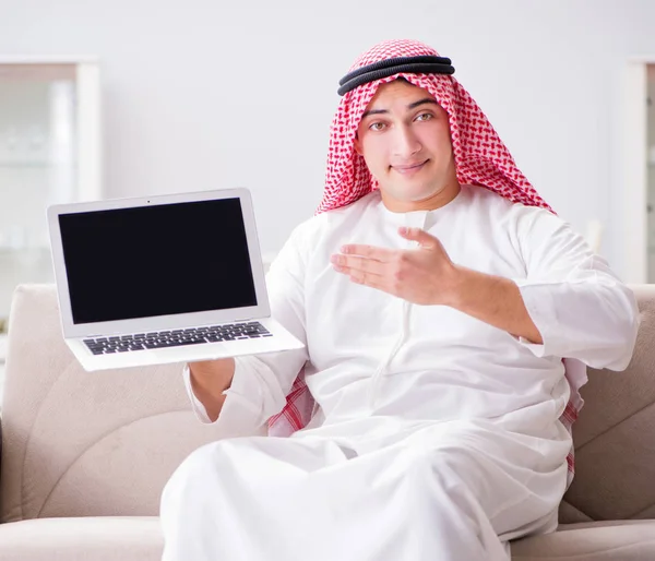 Giovane uomo d'affari arabo che lavora con il computer portatile sul divano — Foto Stock