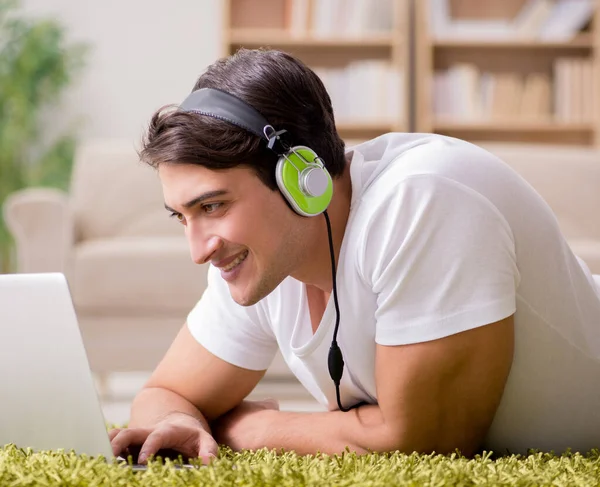 Joven escuchando la música de la computadora portátil —  Fotos de Stock