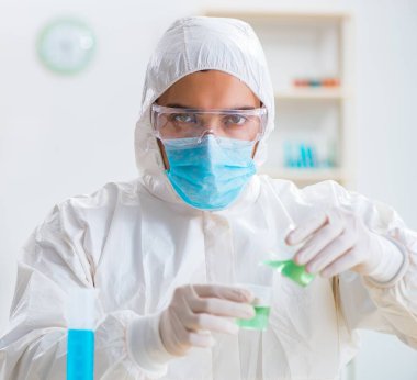 Laboratuvarda kimyasallar üzerinde çalışan genç bir kimyager.