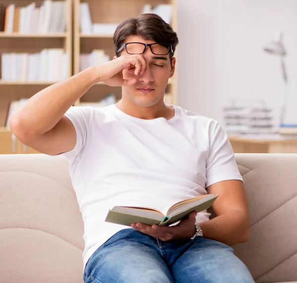 Hombre leyendo libro sentado en sofá sofá —  Fotos de Stock