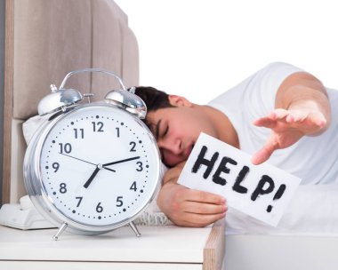 Yatakta uykusuzluk çeken bir adam.