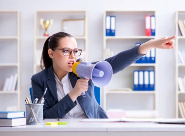 Ofiste hoparlörle bağıran kızgın iş kadını.