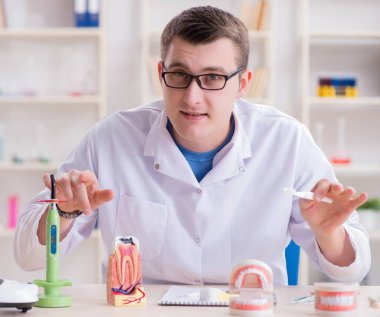 Tıp laboratuarına diş implantı yerleştiren dişçi.