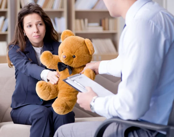 Женщина с медвежьей игрушкой во время посещения психолога — стоковое фото
