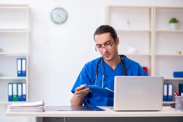 Jovem médico do sexo masculino trabalhando na clínica — Fotografia de Stock