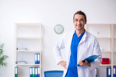 Klinikte çalışan genç erkek doktor.