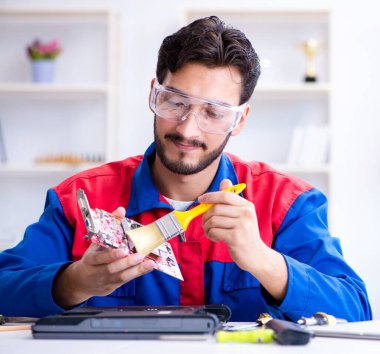 Bilgisayar dizüstü bilgisayarının tamirinde çalışan tamirci.