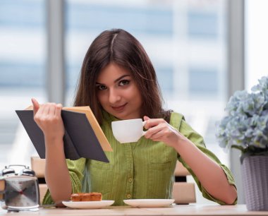 Sınavlara hazırlanan genç öğrenci çay içiyor.
