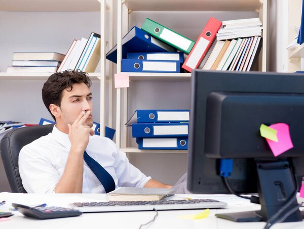 Businessman working in the office with piles of books and papers