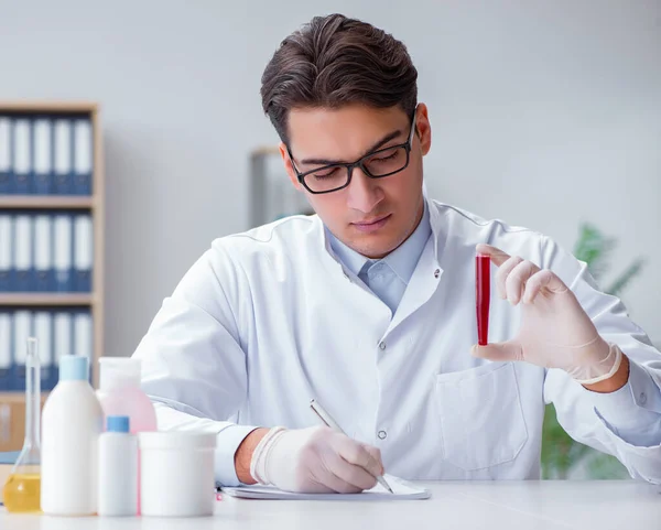 Médico joven en el laboratorio con tubo rojo —  Fotos de Stock