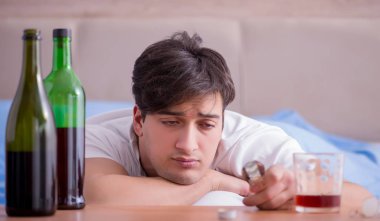 Yatakta içen alkolik adam depresyona giriyor.