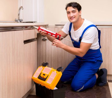 Mutfakta çalışan genç tamirci.