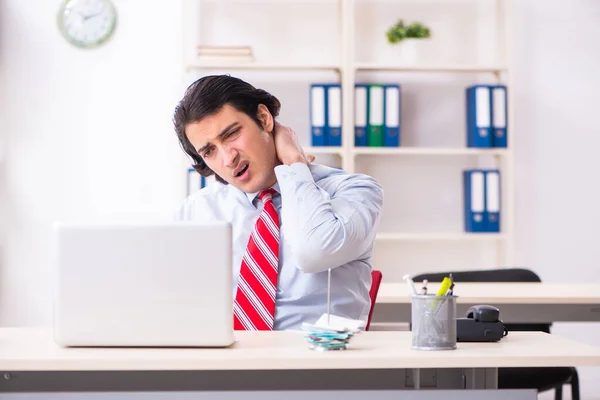 Young male employee suffering in the office — Stock Photo, Image