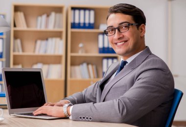 Genç yakışıklı işadamı ofiste çalışıyor.