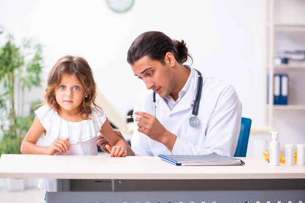 Küçük bir kızla genç bir doktor çocuk doktoru. — Stok fotoğraf