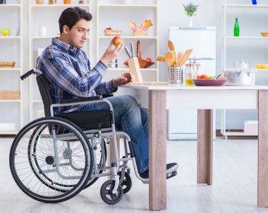 Engelli genç koca mutfakta çalışıyor.