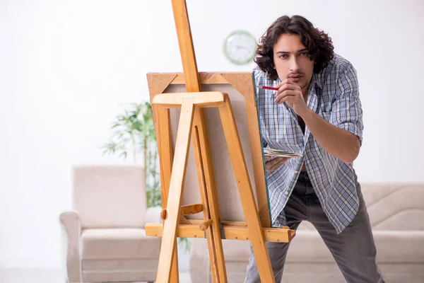 Jovem homem bonito curtindo pintura em casa — Fotografia de Stock