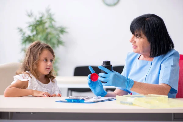 Bambina in visita vecchio medico femminile — Foto Stock