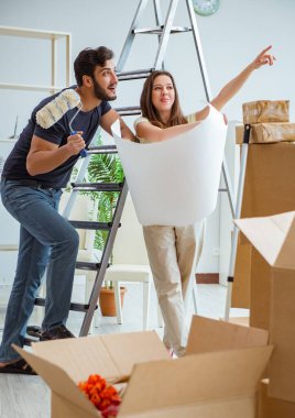 Yeni evdeki kutuları açan genç bir aile.