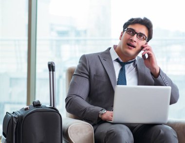 Havaalanındaki iş yerinde genç işadamı uçuş için bekliyor.