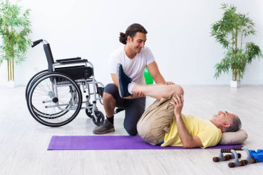 Yaşlı adam içeride egzersiz yapıyor.