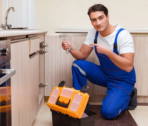 Junger Reparateur arbeitet in der Küche — Stockfoto