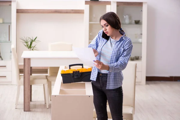 Young beautiful woman assembling furniture at home — Stock Photo, Image